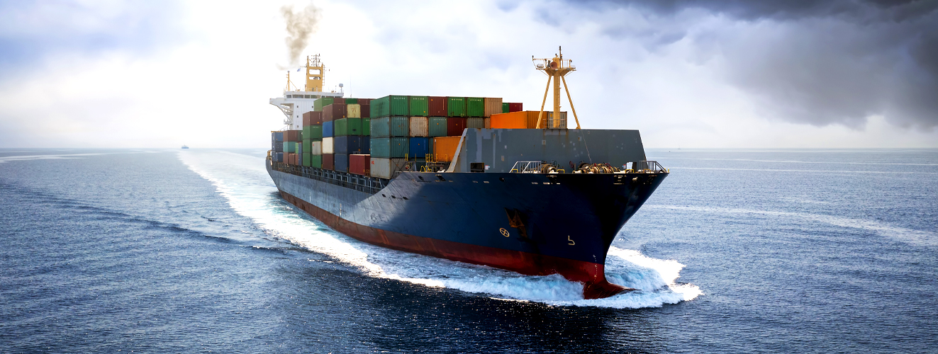 Container ship docked at port with stacked cargo and trucks